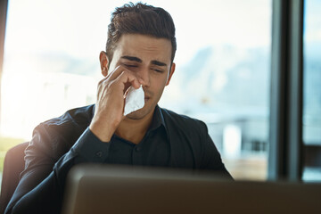 Aufkleber - Feeling a cold coming on. Shot of a young businessman blowing his nose in an office.