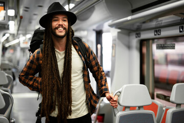 Young man using digital tablet while traveling by a train. Handsome young man traveling by a train.