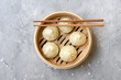 Bamboo steamers with tasty baozi dumplings, chopsticks and bowl of sauce, top view. chinese food, Taiwanese food, Chinese food delivery