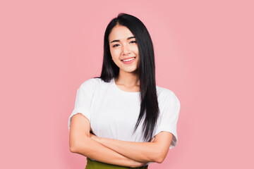 Wall Mural - Asian happy portrait beautiful cute young woman standing her smile confidence with crossed arms isolated, studio shot on pink background and copy space, Thai female looking to camera