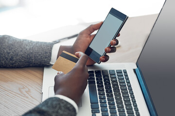 Poster - Business banking has never been simpler. Shot of an unidentifiable young businessman using wireless technology to make an online purchase in the office.