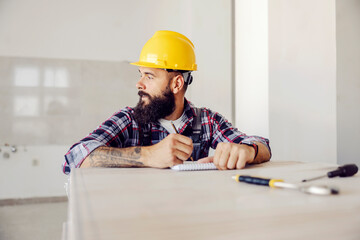 Wall Mural - A handyman doing calculations for materials in apartment in construction process.