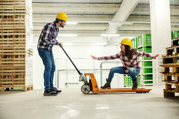 Wall Mural - Workers playing with forklift and having fun at workplace.