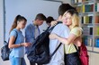© Valerii Honcharuk - Teenage friends students hug when meeting each other in the library