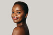 © Strelciuc - Portrait of a young afro american woman looking over shoulder isolated on a beige background. Beautiful female person. Natural beauty. Beautiful african woman