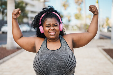 Wall Mural - Happy curvy african woman doing workout routine outdoor - Focus on face