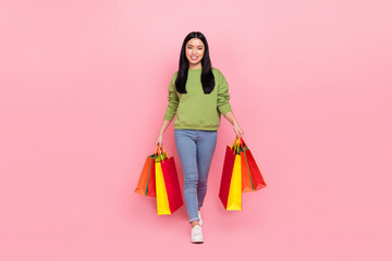 Wall Mural - Full length photo of nice young lady go with bags wear sweater jeans footwear isolated on pink background