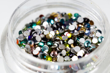 Poster - colored sequins in a plastic jar close-up