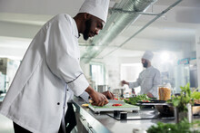 African American Head Chef Chopping Fresh And Organic Vegetables For Gourmet Dish Served At Dinner Service In Restaurant. Food Industry Worker Preparing Garnish For Delicios Food.