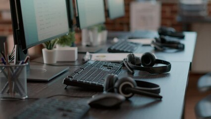 Poster - Empty call center office with computers and audio headsets used to have conversation with people on customer service helpline. Nobody at telemarketing workstation with technology.