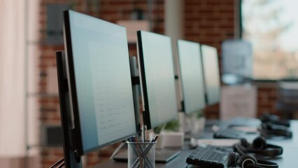 Poster - Nobody at customer care workstation with multiple computers used by telemarketing agents to give support to clients at call center helpline. Empty desks with monitors and headphones.