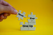 Motivational text on jigsaw puzzle with hand holding a missing jigsaw - Never ever give up.
