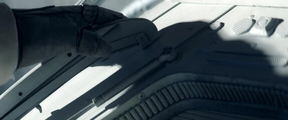 Wall Mural - close up on hand - astronaut performing spacewalk, working on a outer part of a space craft. space e