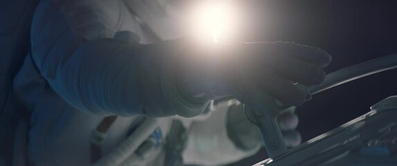 female astronaut performing spacewalk, working on a outer part of a space craft. shot with 2x anamor