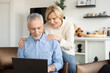 © brizmaker - Mature family couple watching video on laptop