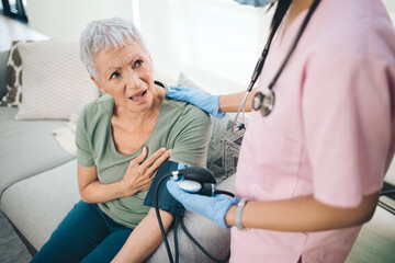 Poster - Those arent butterflies. Shot of a concerned older woman having her blood pressure read at home.