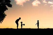 Young Father Playing With His Children In The Park. Fatherhood, And Active Family Lifestyle Concept 