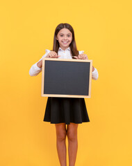 Canvas Print - happy teen girl hold blackboard. child advertising. back to school. presenting novelty information