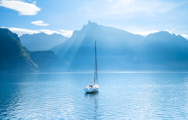 Wall Mural - a yacht against the backdrop of the mountains in switzerland. calm water and bright sunny day. a pop