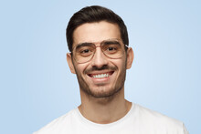 Young Smiling Handsome Man In Glasses And T-shirt Isolated On Light Gray Background