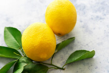 Two Lemons With Leaves On A White Background