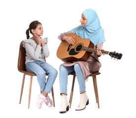 Canvas Print - Private Muslim music teacher giving guitar lesson to little girl on white background