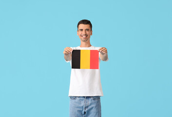 Wall Mural - Young man with flag of Belgium on color background