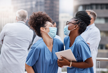 Poster - Bringing in some laughter to brighten up their day. Shot of two young female doctors using a digital tablet in the city.