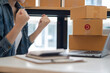 © ArLawKa - Portrait of a Small Business Startup, Owner, Asian Entrepreneur Working on boxes and laptops, checking online orders to prepare boxes. Selling to customers, SME business concept, online sales name