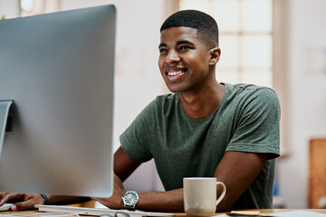 Canvas Print - Love what you do and it wont feel like work. Shot of a young businessman using a computer in a modern office.