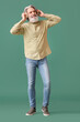 © Pixel-Shot - Bearded senior man in headphones on green background