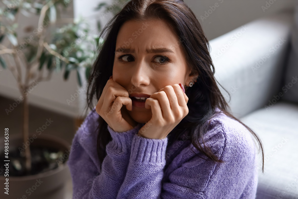 Worried young woman sitting at home