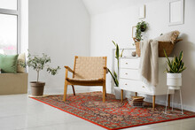 Interior Of Cozy Living Room With Armchair, Chest Of Drawers And Vintage Carpet
