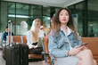 © 2B - Woman sitting with suitcase in hotel lobby or in an airport lounge