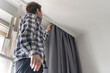© Mihail - man doing house works, attach the railing and hang curtains at home