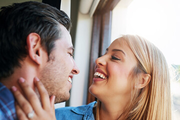 Poster - Im so in love with you. Cropped shot of an affectionate young couple standing at a window in their home.