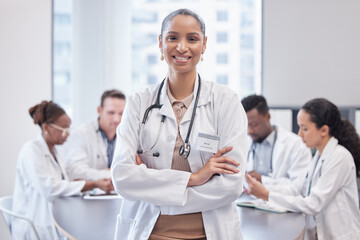Poster - Confident with an awesome team behind me. Cropped portrait of an attractive young female doctor standing in the boardroom with her arms folded with her colleagues in the background.