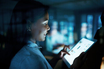 Poster - Its never too dark for creative light to shine through. Shot of a young businesswoman using a digital tablet during a late night at work.