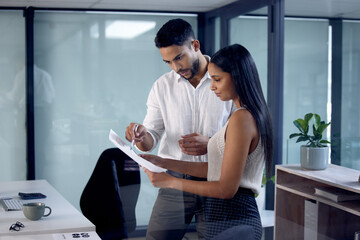 Poster - What do you think about it. Shot of two work colleagues reading over some documents together.