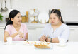 © offsuperphoto - mother with down syndrome teenage girl or her daughter, eating apple together in a kitchen