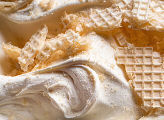 Wall Mural - Frozen Creamy flavour gelato (called Russian Ice Cream) - full frame detail. Close up of a white surface texture of Ice cream covered with pieces of broken waffle.