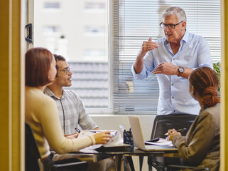 Aufkleber - let me explain. cropped shot of a handsome mature businessman explaining an idea to his colleagues i