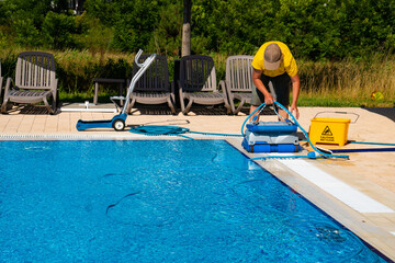 the cleaner turns on an automatic cleaning robot to clean the pool. automatic pool cleaning. concept