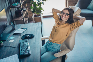 Poster - Portrait of attractive cheerful skilled girl company outsource technician sitting in chair at workplace workstation indoors