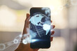 © Pixels Hunter - Double exposure of robotics technology with world map hologram and hand with cell phone on background. Research and development software concept