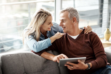 Poster - Theyve got an undeniable connection. Shot of a mature couple using a digital tablet while relaxing together on the sofa at home.