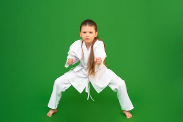 Sticker - A child in judo training. A little girl studies martial arts, a children in aikido training