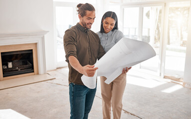 Are you happy with the final plan. Shot of two young architects looking at building plans on site.