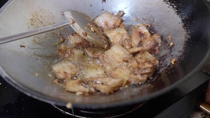 Wall Mural - Cooking deep fried pork belly with garlic and pepper in hot pan