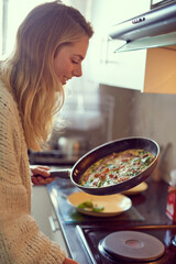 Poster - Its her favourite meal to make. Cropped shot of an attractive young woman cooking in her kitchen.